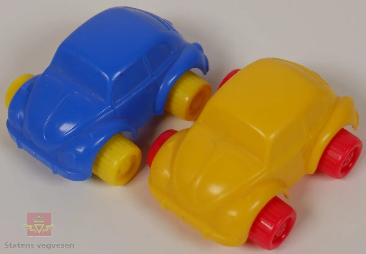 Miniatyrbiler av Volkswagen Beetle. Det er to biler i forskjellige farger, den ene er blå med gule hjul og den andre er gul med røde hjul. Bilene er laget av plast med akslinger til hjulene i metall. Innskriften FLEXI TOYS SWEDEN Made in Thailand på undersiden av bilene.