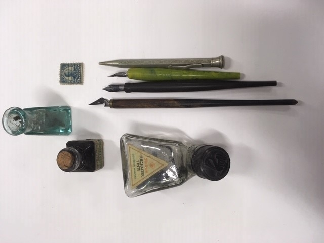 Reiseskrivebord i tre, mahognifinèr, skriveplate med grønn filt. Inneholder 3 blekkhus, 3 penner med pennespiss, 1 mekanisk blyant, 1 frimerke. Ang. tilhørt Oscar Borg.