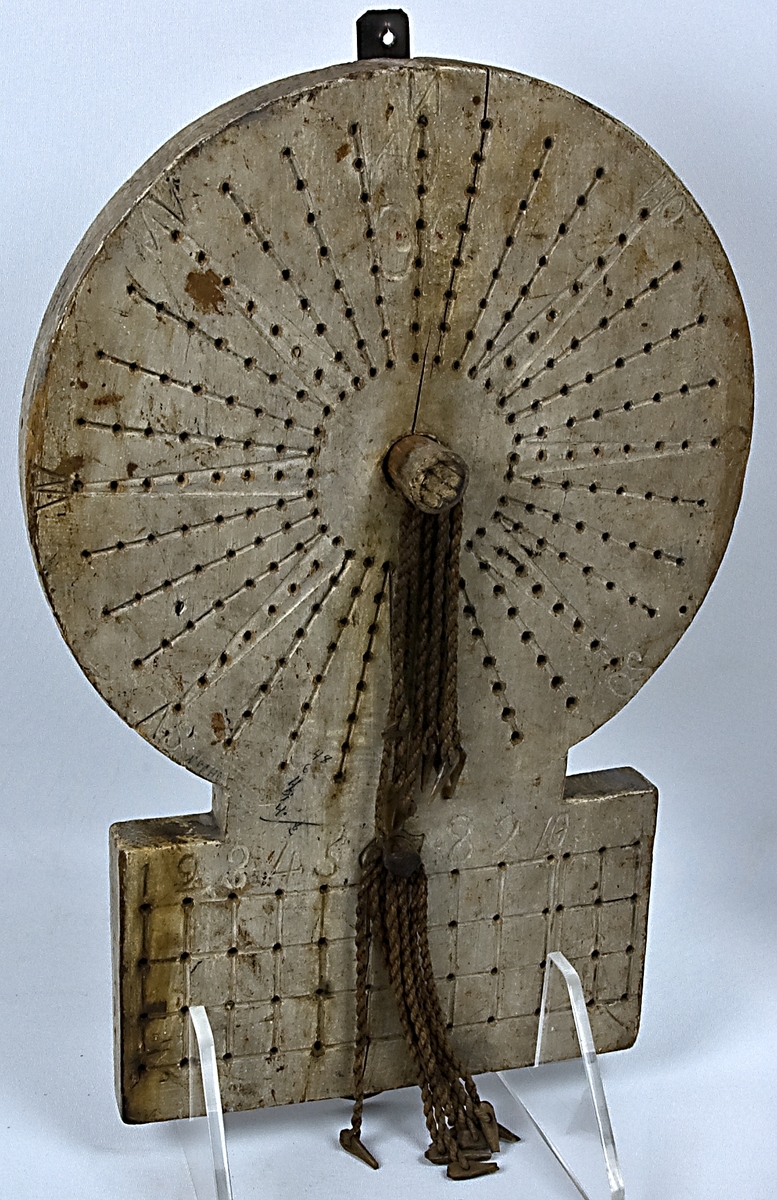 Pinnkompass från "Gerda" av trä. Använd såsom loggbok under kryssning.
Träskiva med pinnar fäst i korta snören.