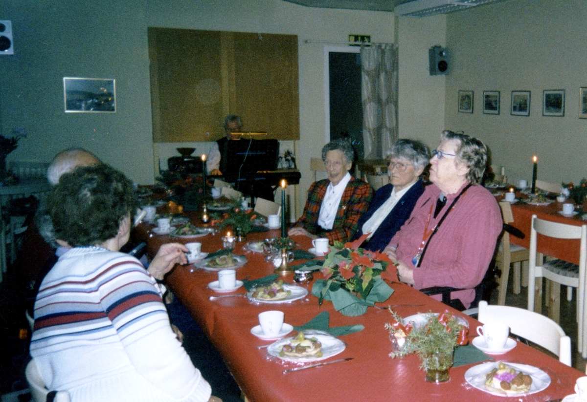 Julkaffe för äldre medlemmar i Kållereds PRO-lokal på Gamla Riksvägen 44 (Värdshuset), 1990-tal. Okända personer till vänster. Från höger: Sigrid Börjesson (i rutig kavaj), Anna-Lisa Larsson samt okänd kvinna.
(PRO = Pensionärernas Riksorganisation).