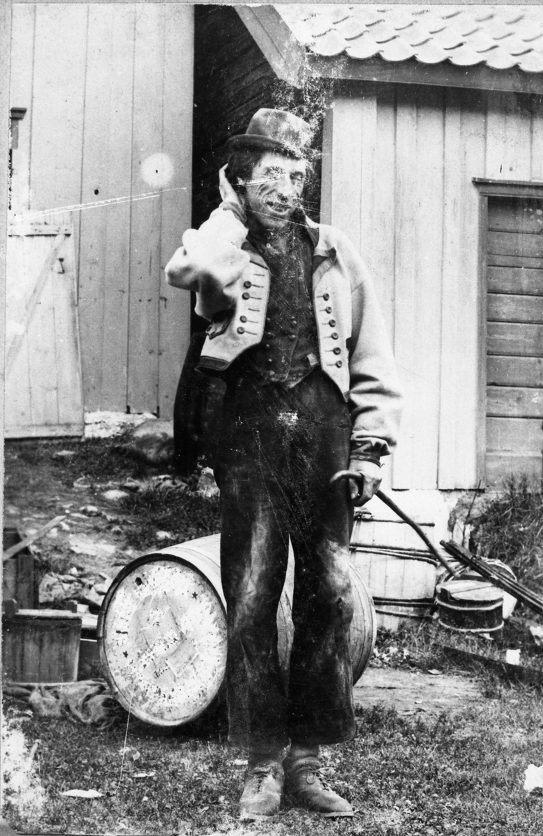 Fotosamling etter Øystein O. Kaasa. (1877-1923). Portrett av mann i folkedrakt fra Øst Telemark, med stokk. Portrettet er opprinnelig navnitt "den sure svie"