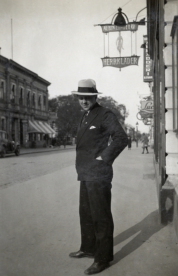 En man i kostym och hatt poserar för fotografen på en stadsgata. 
Under fotot text: "Pettersson Bergvik".
