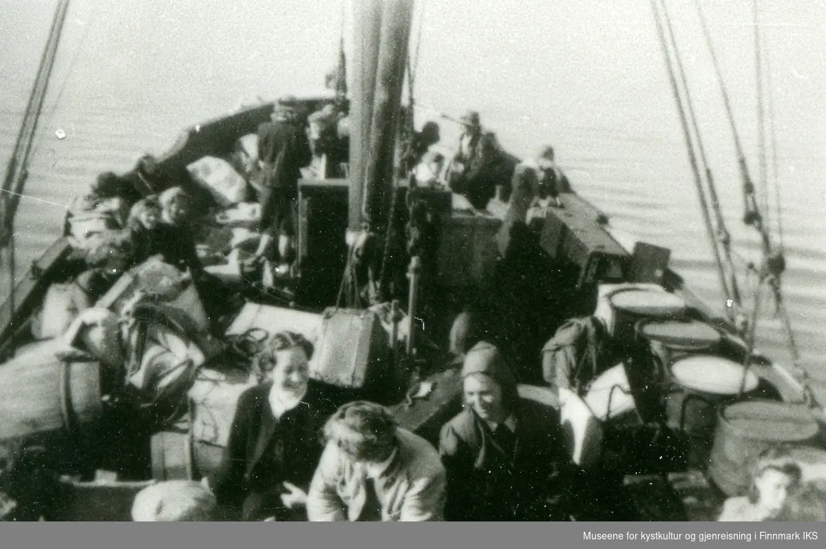 Båttransport av flere personer, tønner og bagasje. Det antas at båten er M/k "Snorre" (F-70-K). 1939-1944.