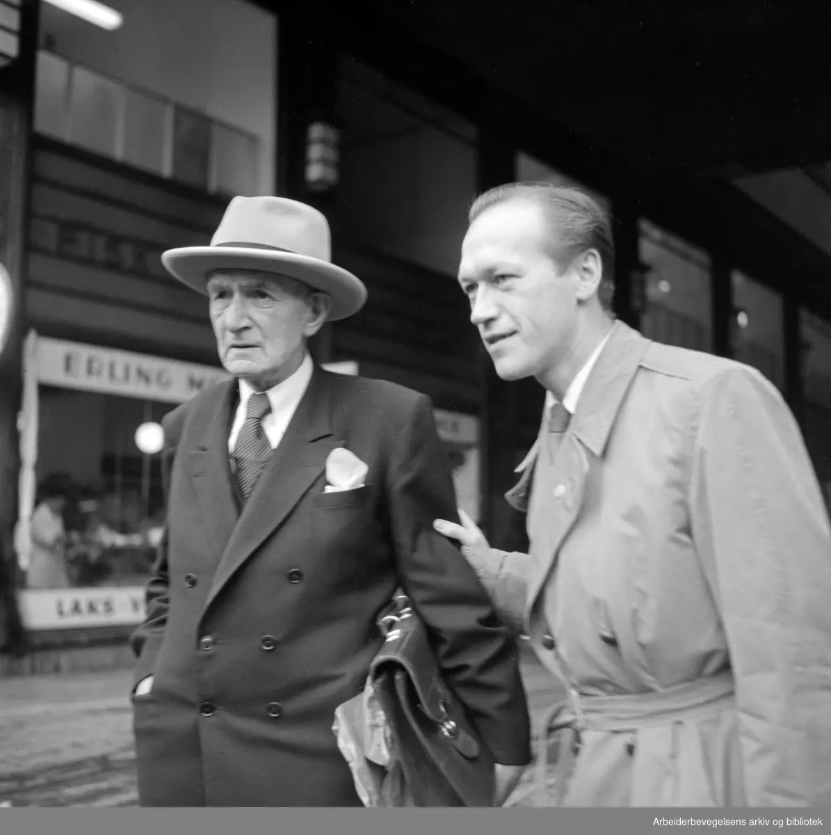 Forfatteren Johan Falkberget (til venstre) og Arbeiderbladets journalist Leif Herbrand Eriksen i Folketeaterpassasjen. Oktober 1954.