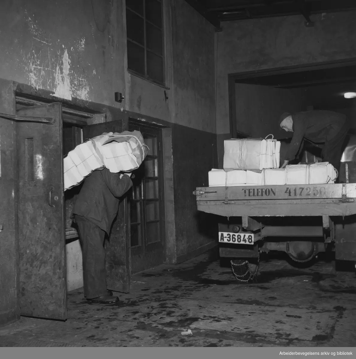 Arbeiderbladets pakkeri. Avisen kjøres ut fra produksjonslokalene i kjelleren på Youngstorget. Januar 1948.