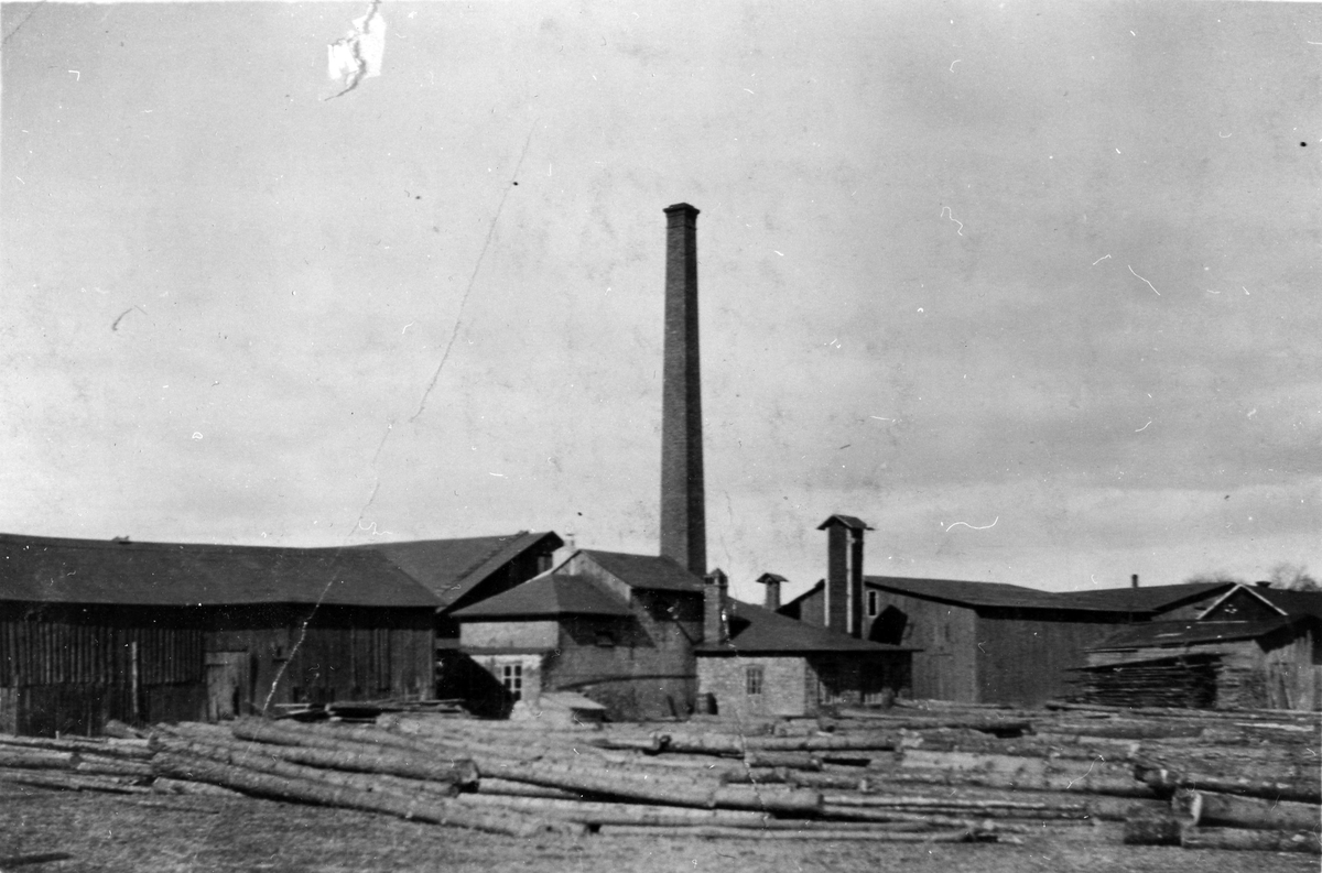 Alingsås snickerifabrik i kv. Gjutaren. Framför fabriken ligger trädstammar.
