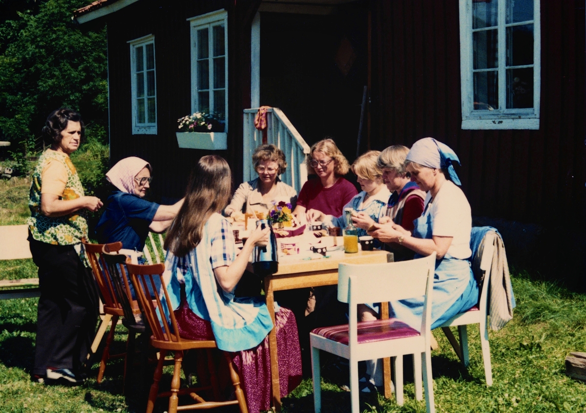 Hantverksdag utanför Långåker Hembygdsgård, 1980-tal. Från vänster: 1 (stående) Dagmar Svensson, Vommedal, 2 Mary Ekman, Vommedal, 4 Ingegerd Benkel, 7 Emy Johansson, Torrekulla. Övriga är okända.
