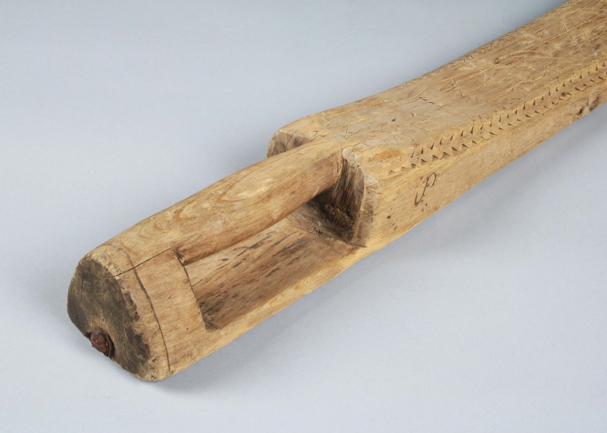 Mangelbräde i ofärgat trä. Handtag och bräde i ett stycke; fasade kanter med uddsnitt; längs mitten stiliserad kruka med blomstängsel. På ovansidan närmast handtaget skuret: "IOD 1790 ANO". På kanternas sidor brännstämplat: "AOS" samt "S". (Gunnar Blomgren)

Mangelbräde eller kavelbräde är ett redskap av trä som använts för mangling av textilier. Mangelbrädet användes tillsammans med en kavel, en slät rulle av trä. Den textil som skulle manglas, rullades upp på kaveln, på ett bord eller annat slätt underlag. Under hårt tryck, rullades kaveln med hjälp av mangelbrädet, fram och tillbaka över bordet. (Wikipedia)