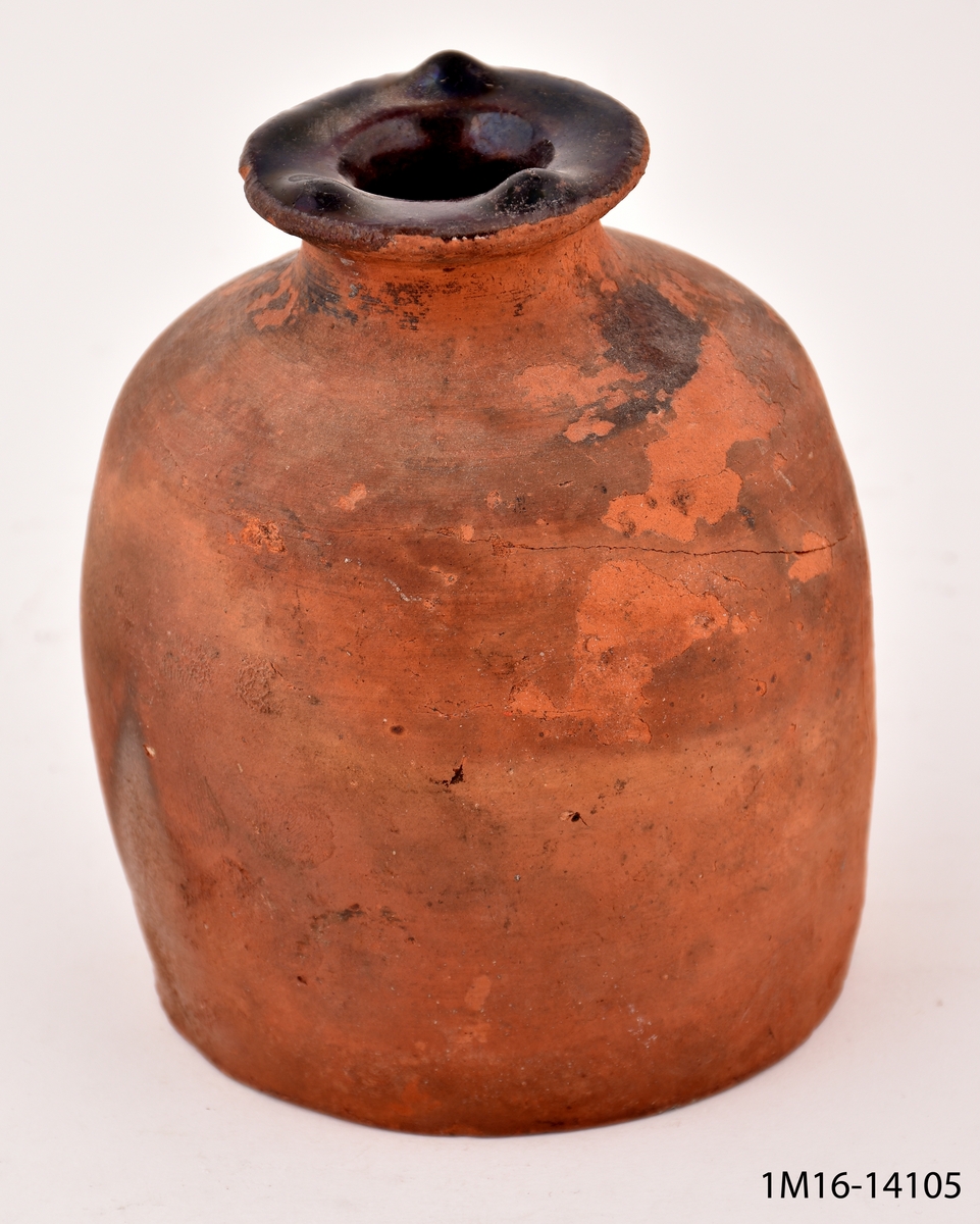 Urna av lergods med smal öppning. Glaserad på insidan och på mynningens ovansida.