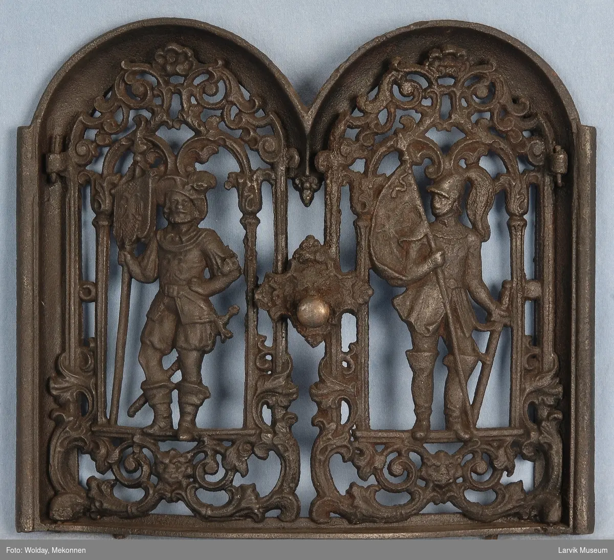 Dørene har gjennombrudt ornamentikk med en ridder midtstilt i en dbl. bueformet ramme