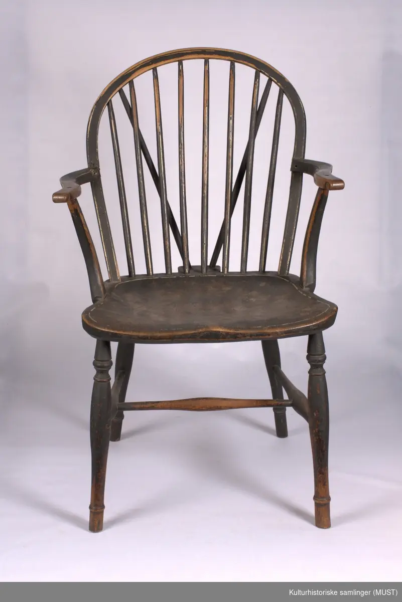 Sortmalt stol med hvit strekdekor. Stolen er bøyet og sveifet. 
Dreide bein, sveifete armlen og armlenstøtter. Dreide bein og sprosser. 
Ryggen består av avsmalede spiler. 
H-kryss og dreide sprosser.