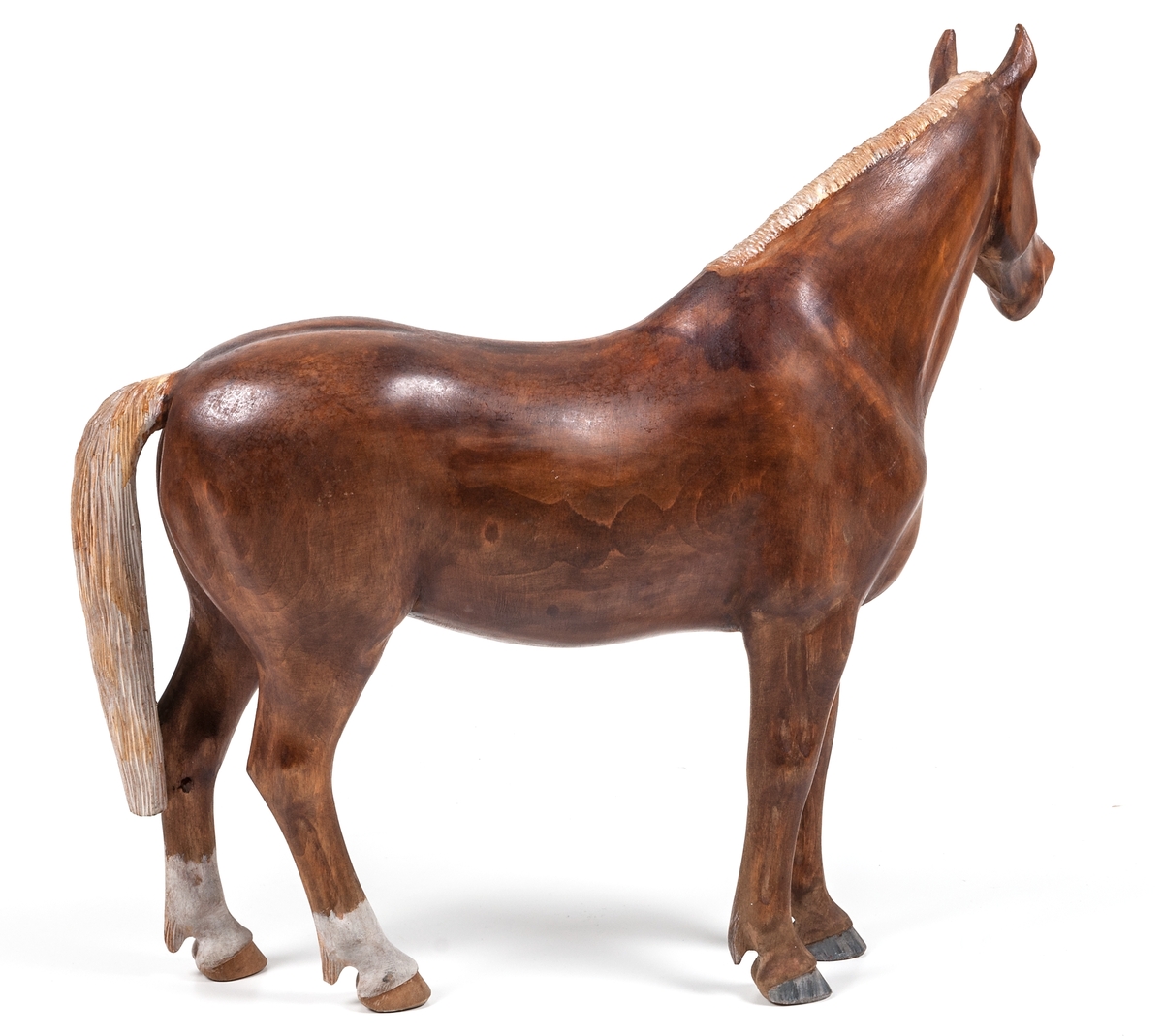 Träskulptur "Häst" av Lars From (1867-1945) från Hälsingland. Naturalistisk häst. Brun med vit man och svans. Vita strumpor på bakbenen. From brukar signera sina hästar med initialerna LF på någon av de bakre hovarna. Denna häst verkar vara osignerad.