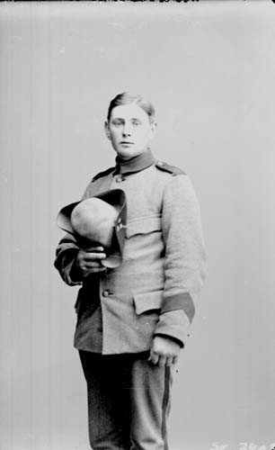 Porträtt av en ung man, beväring i uniform. Han håller en trekantshatt i handen.