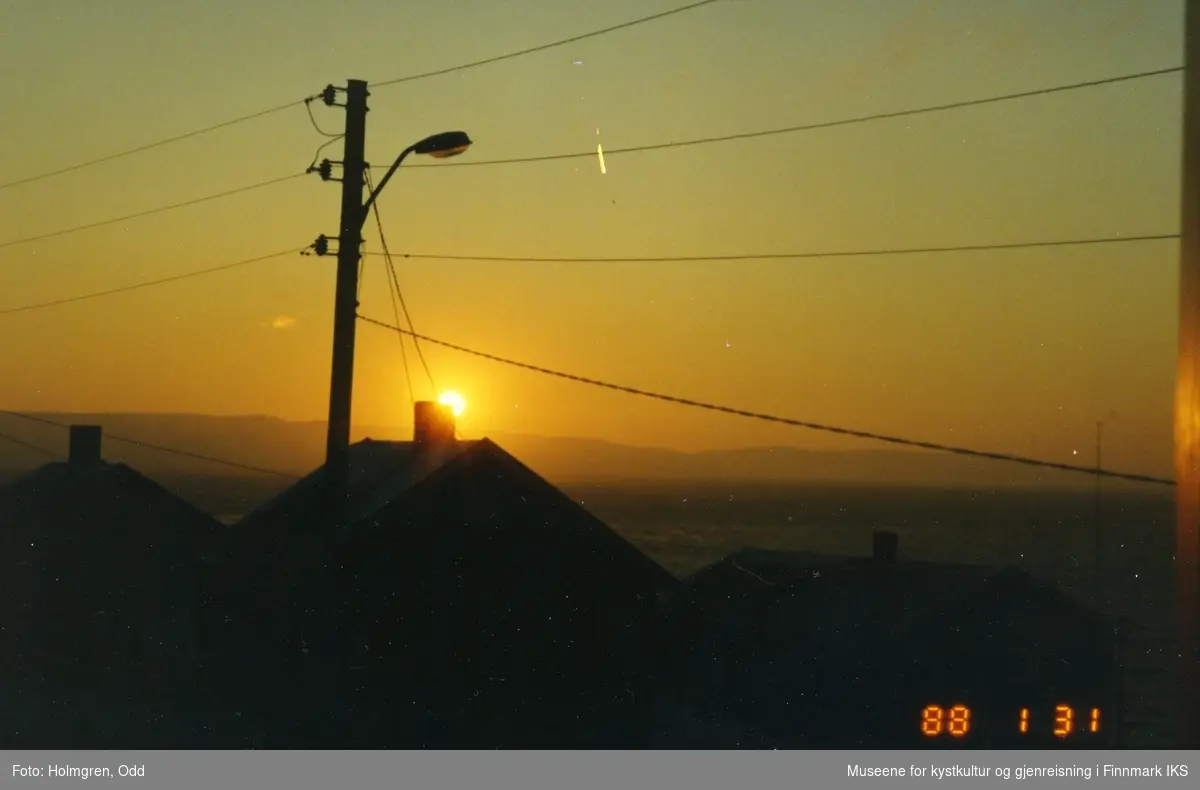 Wintersol over Honningsvåg. Mørketiden har vært over i ca. en uke. 31.01.1988.