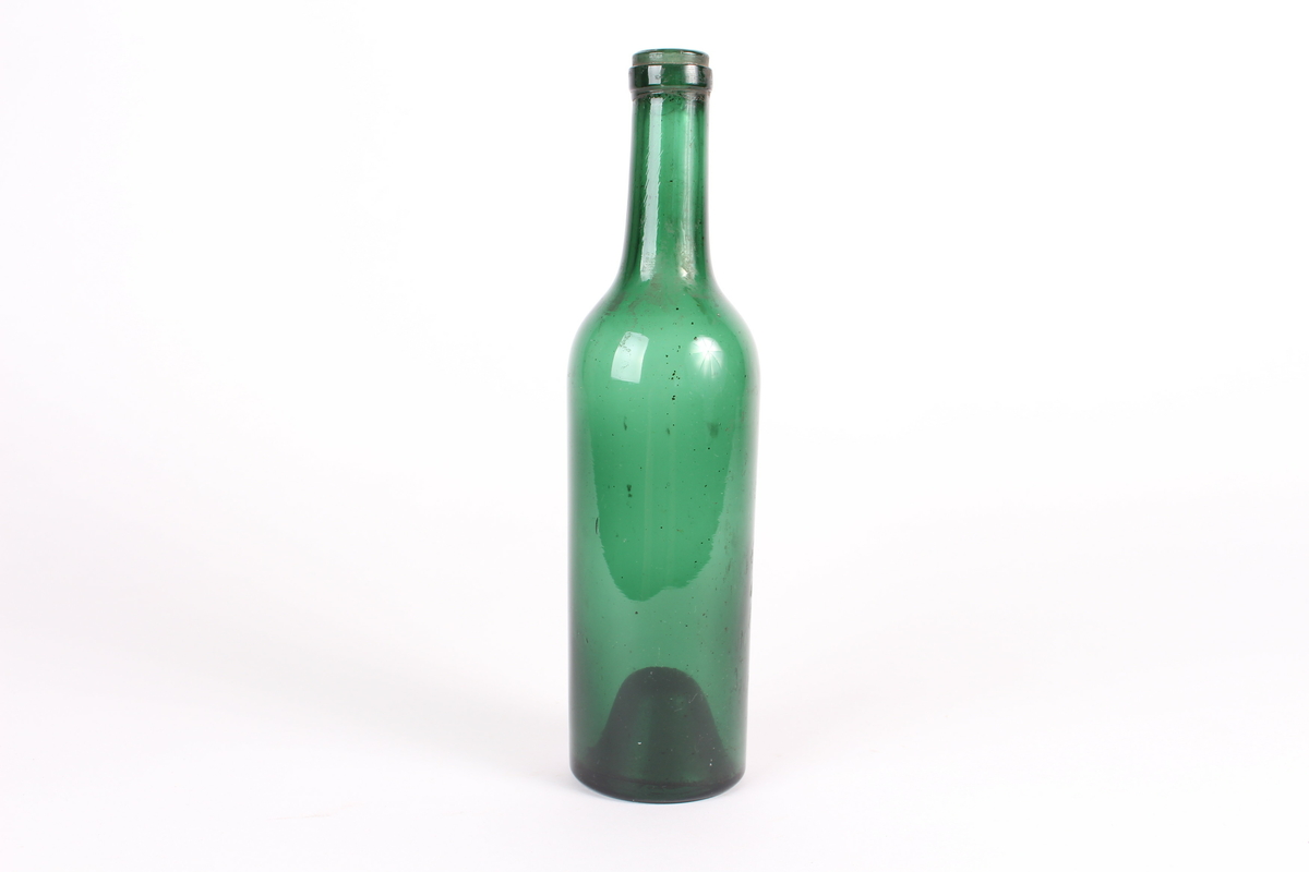 Grøn glasflaske til oppbevaring av drikke, utan kork.