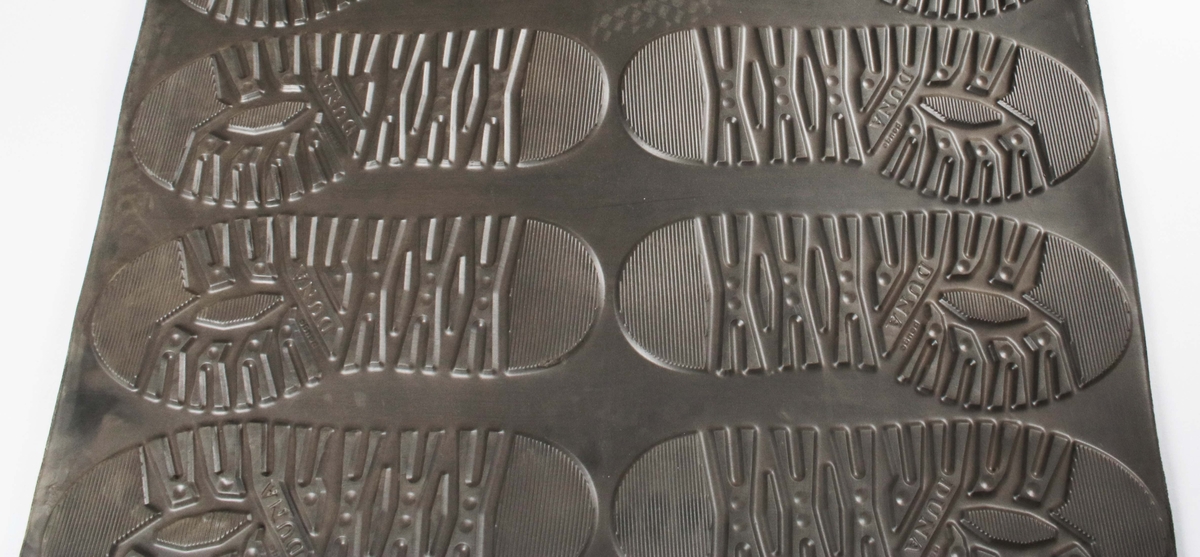 Rektangulär gummiplatta, med 16 gummisulor i relief, för tillverkning av skodon. 8 för höger fot och 8 för vänster fot. Färdiga för utstansning.
Sulorna märkta: DUNA Peuge