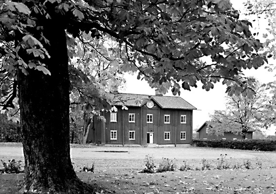 Större träbyggnad i två våningar med urliknande föremål på väggan..Fotografens ant: Godsägare Viberg Apertin Kil 1942