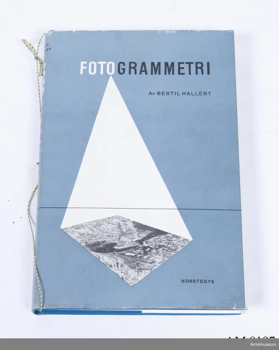 Bok. Bertil Hellert: Fotogrammetri. Boken har ett skyddsomslag. Papper gråblått med vit och svart text, (fotogrammetri) av Bertil Hellert. På förlagan förekommer stavningen Hallert och Hellert.