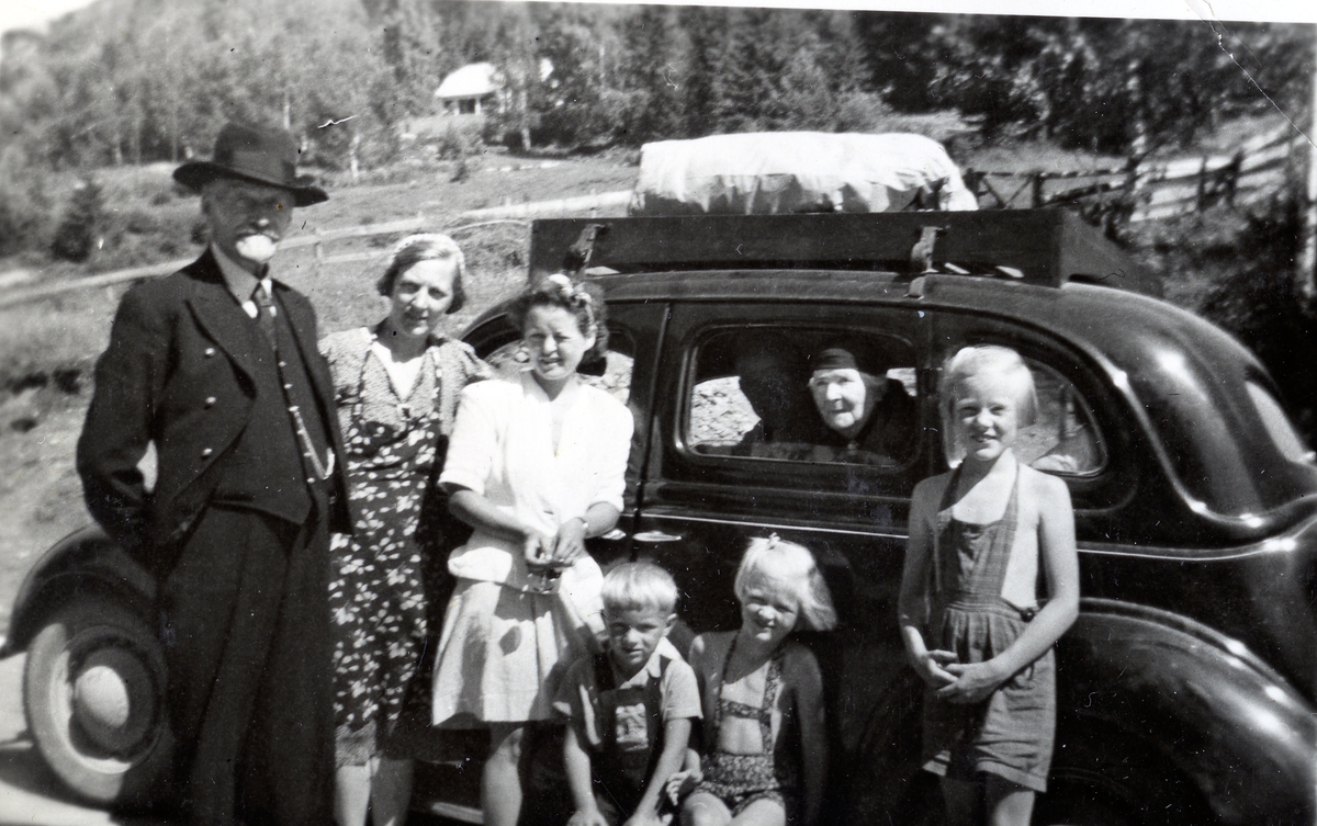 Frå venstre: Jakob Naadland, Ingrid Naadland, Elsa Marstrander(?), Olav Naadland jr., Liv Naadland,Arnhild Naadland
Inni bilen: Kitty Naadland.