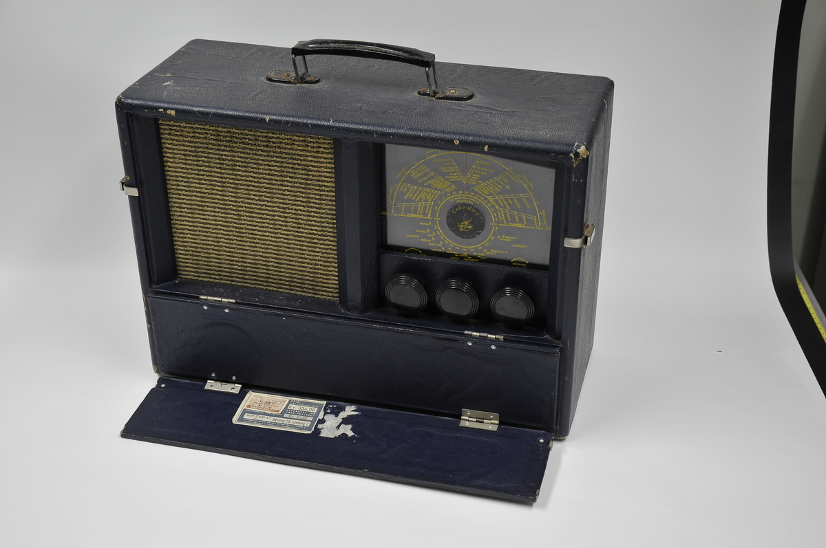 Høvding radio modell Camping 2 fra 1940-tallet. 
Campingradio brukt i Harstad. Håndtak i metall på toppen, og to klaffer som felles ned foran før bruk. Klaffene skuler høyttaler og knapper for betjening. På baksiden er det kontakter for antenne og strøm.