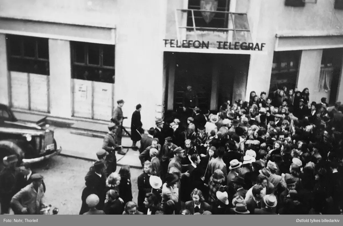 Frigjøringsdagene i Halden i mai 1945, etter andre verdenskrig.Folkemengde ved telegrafen. Grensepolitiets (Grepo) kontorer i Telegrafbygningen  blir besatt 9. mai av en milorggruppe.