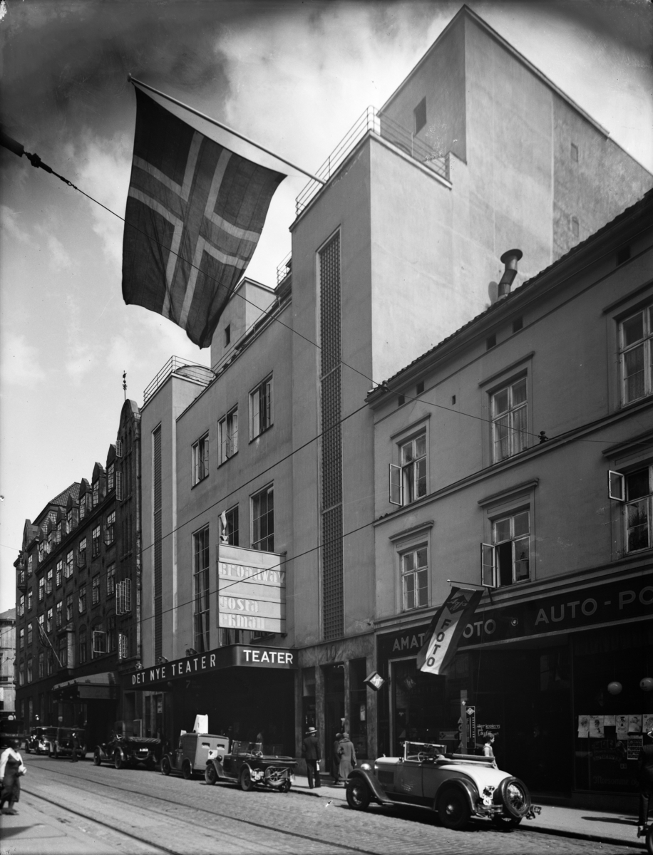 Et flagg vaier foran fasaden til Det Nye Teater.