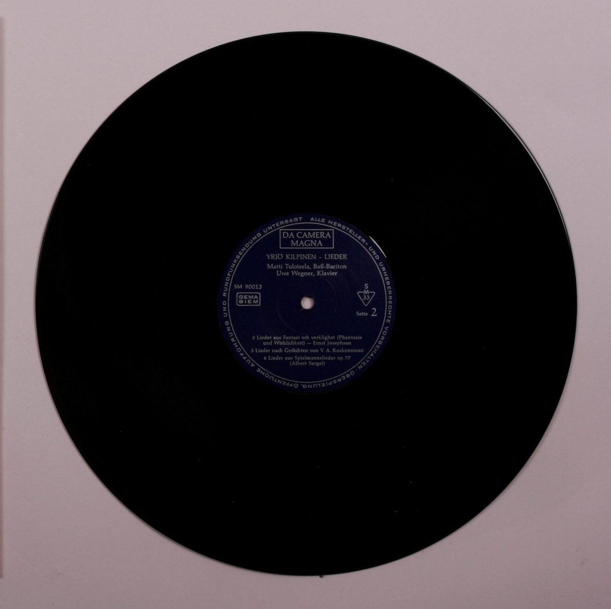 Grammofonplate i svart vinyl og plateomslag i papp. Plata ligger i en papirlomme.
