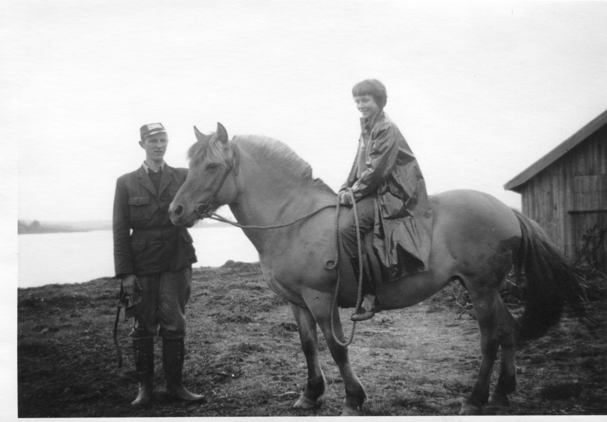 Knut O. Vistemyren står ved sida av hesten. Jenta som rir er ukjent.