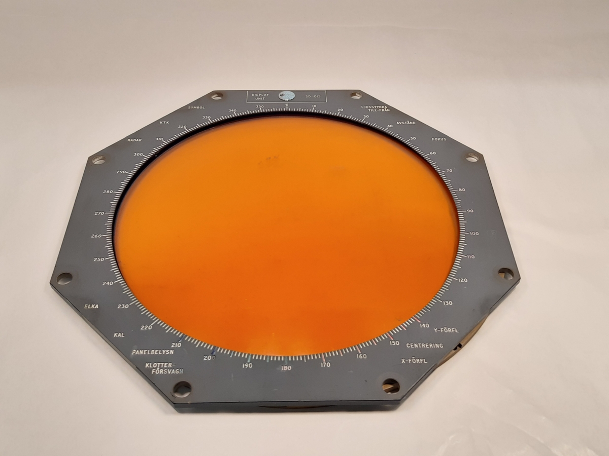 Radardisplay, SD 1015, i tre lösa delar. Radardisplayen består av en orange skärm med metallram. Ovanpå denna vilar en plastskärm med svartmålad kant. Samt en grå ram med gradering. 
Baksidan märkt: "E/RAD/D. 70581. ISS.I", samt "WZ. 27510. P1690. ISS.I."