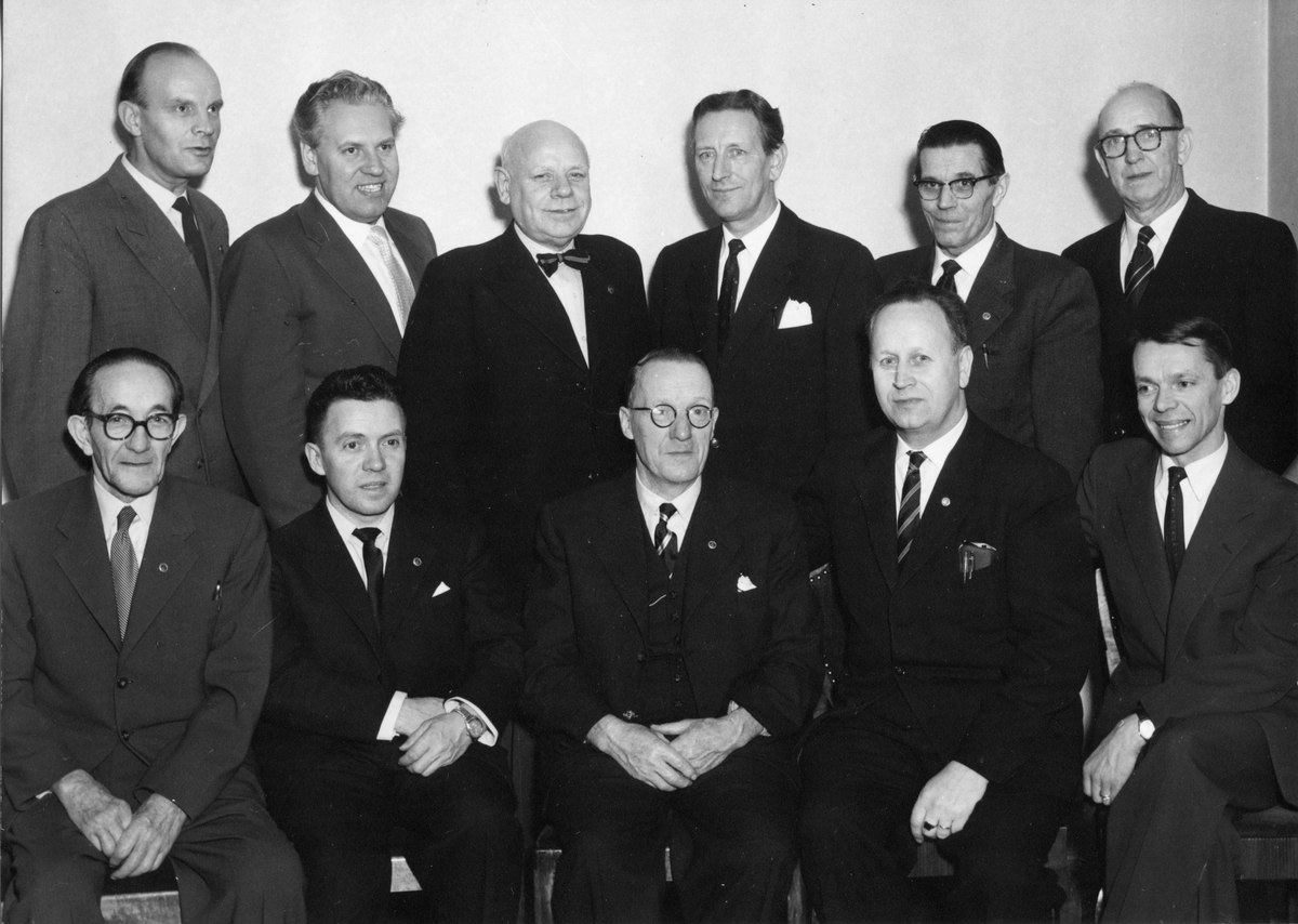 Gruppfoto på 11 män i kostym, främre raden sitter och de andra står bakom.