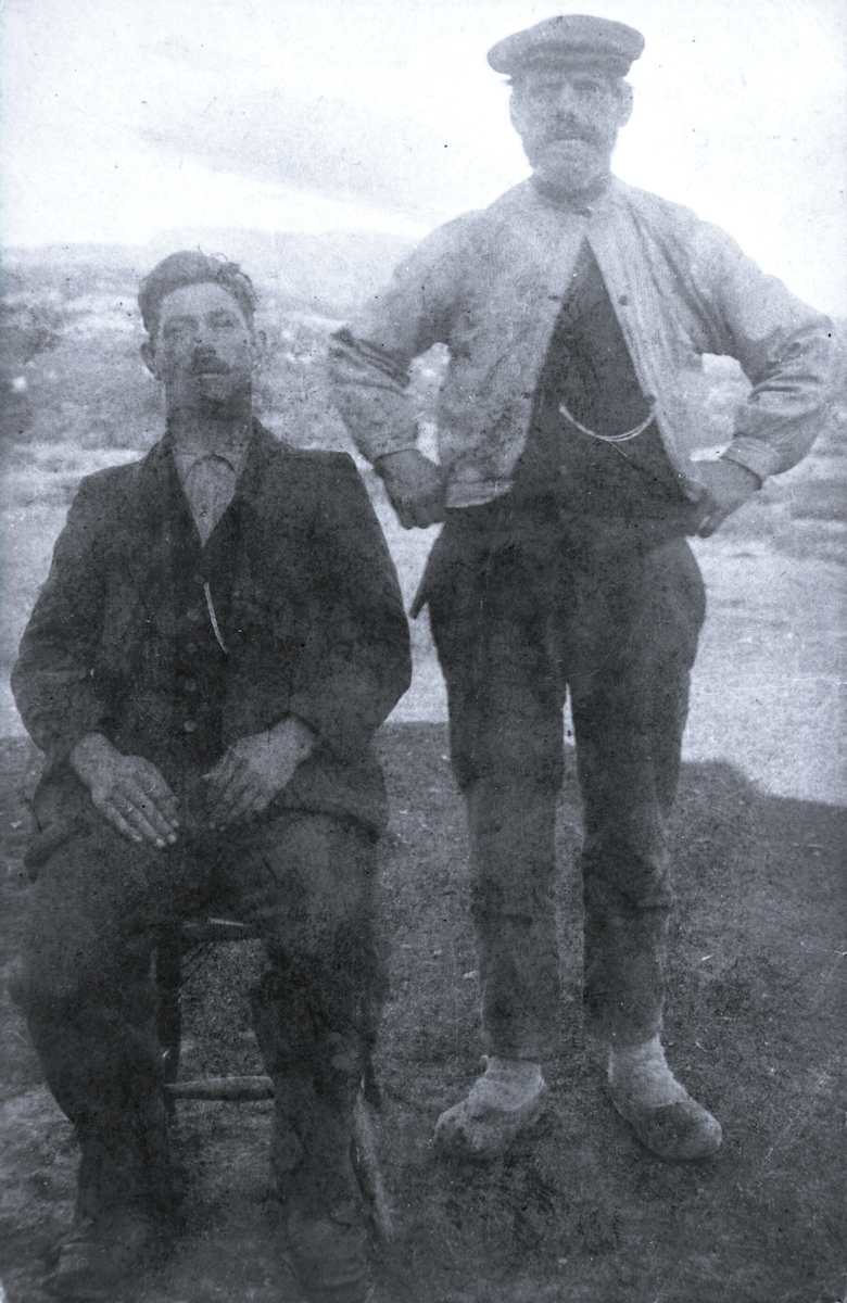 Nils Sigurdsson Folkestad  (sitjande) og faren Sigurd Kultan (ståande) på Hollane i kvardagsklede.  Fotoet er frå ca. 1920.  