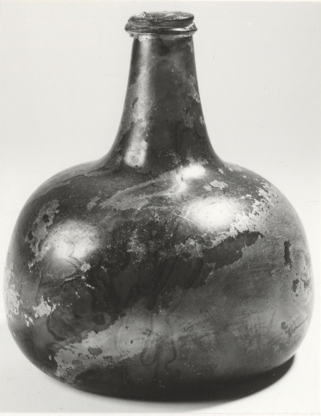 Bukig flaska med grönt glas, antydan till axlar. Troligen tidigt 1700-tal.