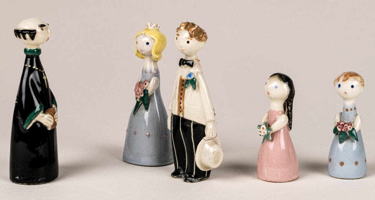 Brudfölje om fem figuriner: präst, brud, brudgum och två tärnor. Formgivare Dorothy Clough, 1955, Gefle Porslinsfabrik.
Prästen är 10 cm hög, bruden 9,5 cm, brudgumen 10 cm, näbbarna 6,7 cm.