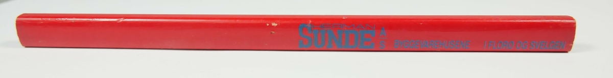Rød rektangulær blyant med blå innskrift. Blyanten er ikke spisset. 