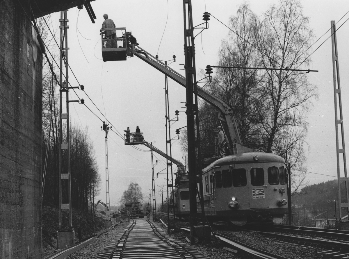 Järnvägsspåret i Anneberg, Lindome, hösten 1990. Montage av kontaktledningar som sker med hjälp av lyftkorgar fastsatta i tåg.