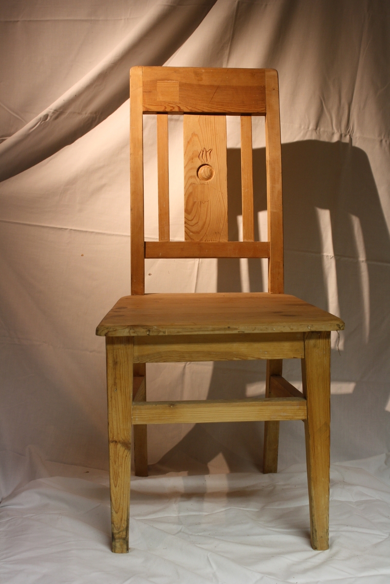 2 st omålade stolar av trä. 
På ryggstödet symol med klot och flamma. 
En stolen stämplad med "Komp 5.  I.4" på sitsens undersida.