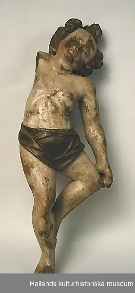 Snidad figur ("putti") av trä, hudfärg, brunt hår, bronserad gördel.