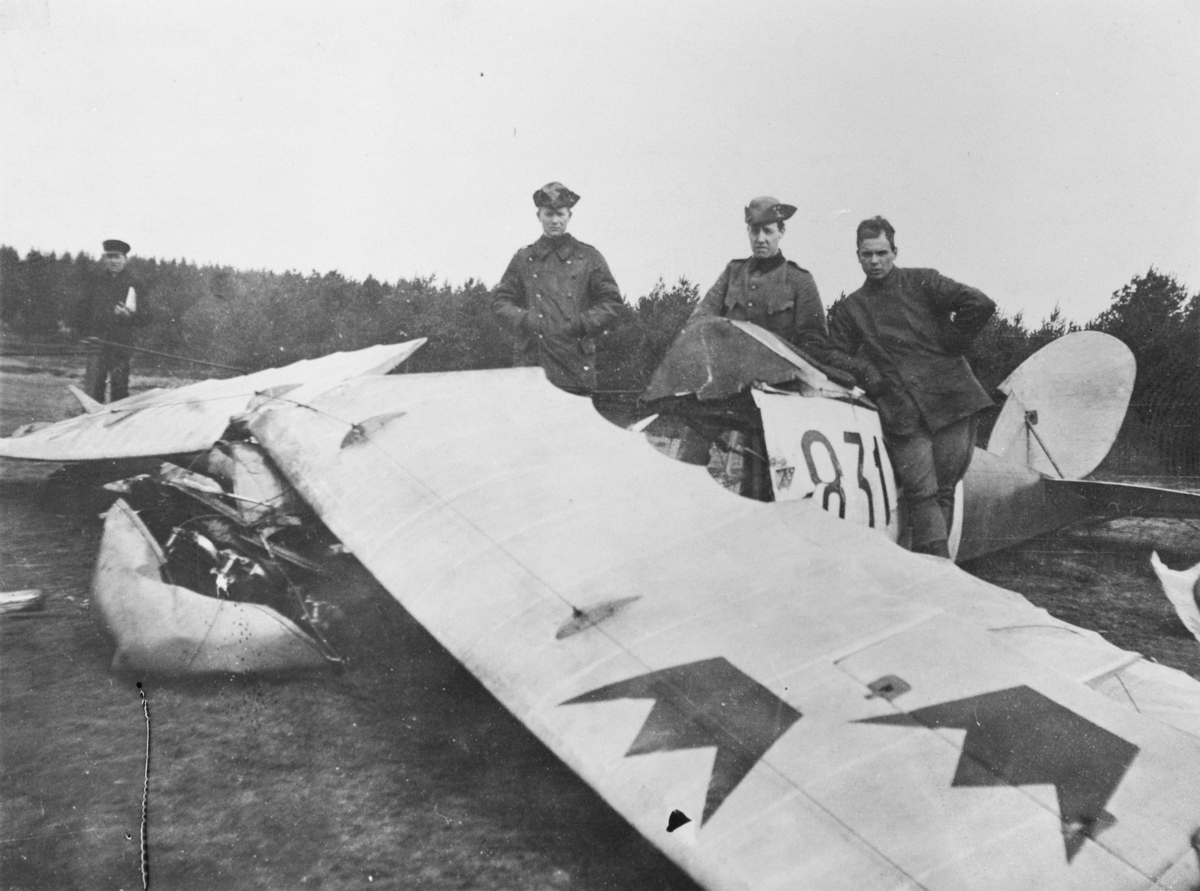 Flygplan FVM Triplanet nr 831 efter haveri den 12 april 1919 i Malmslätt. Tre militärer vid flygplanet.