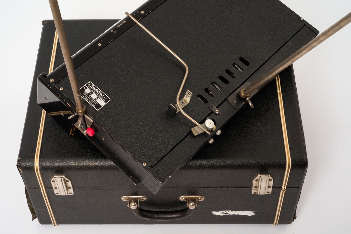 Clavioline (a) med tre metallføtter og tilhørende kasse (b). Kassa fungerer som både forsterker og høyttaler. Instrumentet er enstemt.

Svært tidlig elektronisk instrument.
Type CM, serie 7, nr 1335.