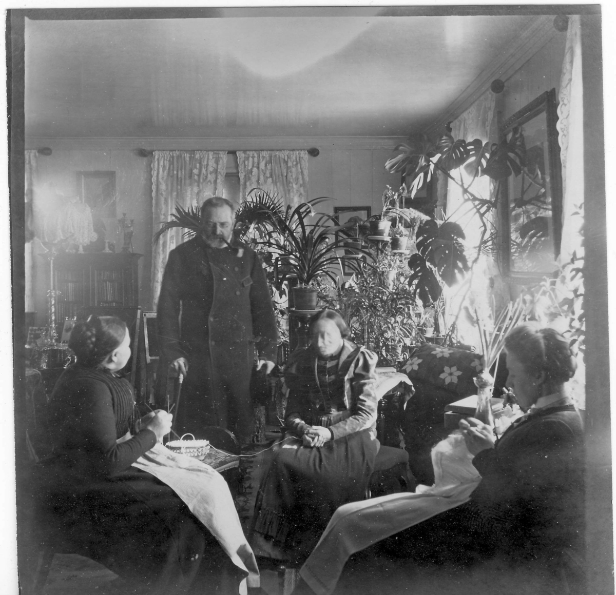 Herr og fru Holtermann pluss gamle tante Lina og Ingeborg i stuen. Holtermann stående med pipe og stokk.