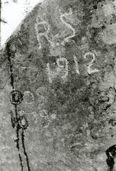 Årstall og initialer hogd i fjellvegg på fylkesveg 42 i Mykl