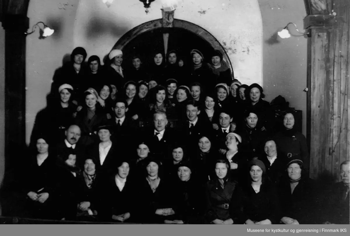 Gruppebilde av baptistmenigheten i Honningsvåg. De poserer i kirkesalen på det gamle Betania ca. i 1930. Til høyre i bilde, bak gruppa, ser man orgelet.