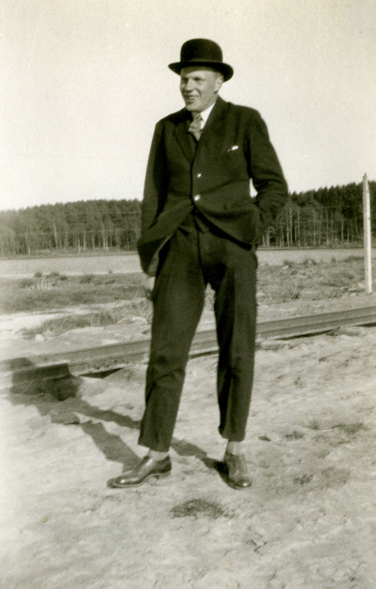 En okänd ung man, uppklädd i kostym och hatt, är på besök vid omläggningen av Västkustbanan, Sagsjön slutet av 1920-talet.