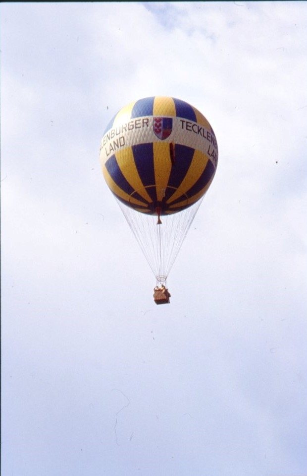 En blågul-randig västtysk vätgasballong i luften. Den är märkt "Tecklenburger Land".