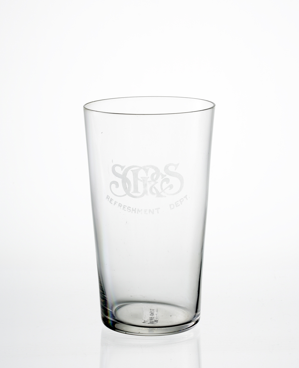 Design: Okänd. 
Selterglas. Svagt konisk kupa med etsat monogram: "SGR & S" och text: "Refreshment Dept."