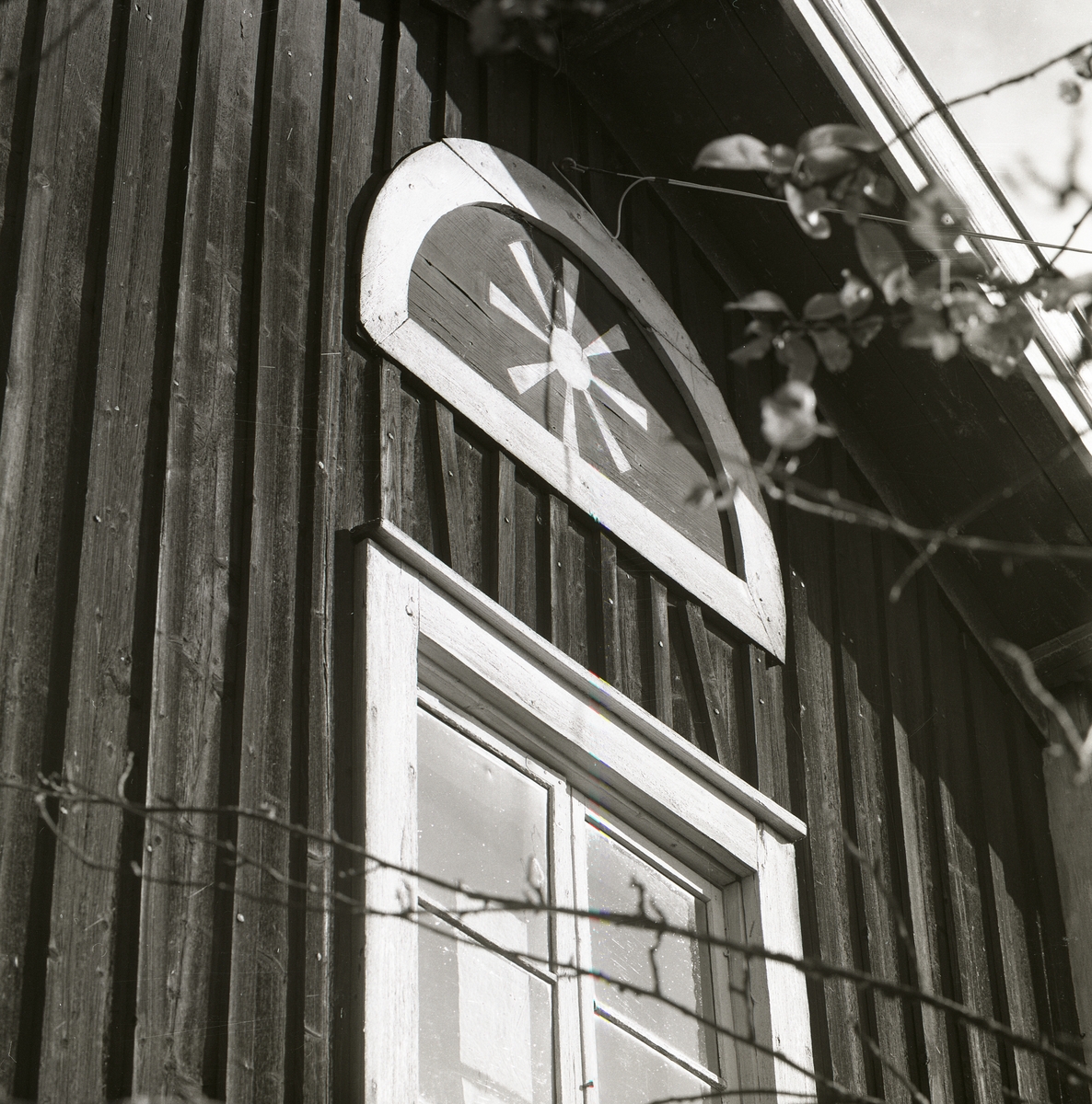 Ett målat blindfönster med sol på husgavel av trä, Lindefallet 1980.
