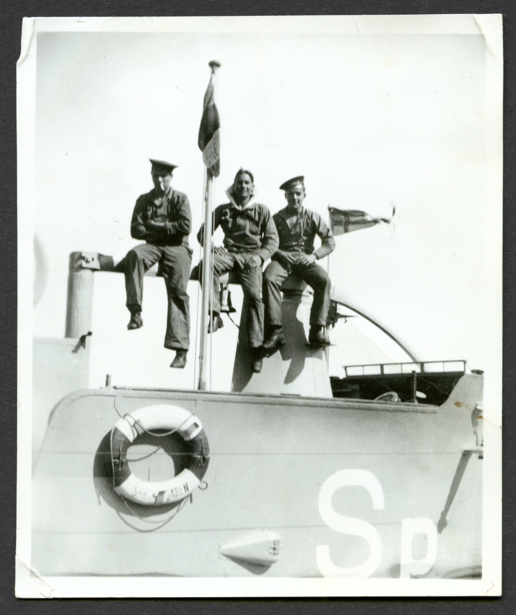Bilden visar tre sjömän som sitter uppe på tornet av ubåten Springaren.