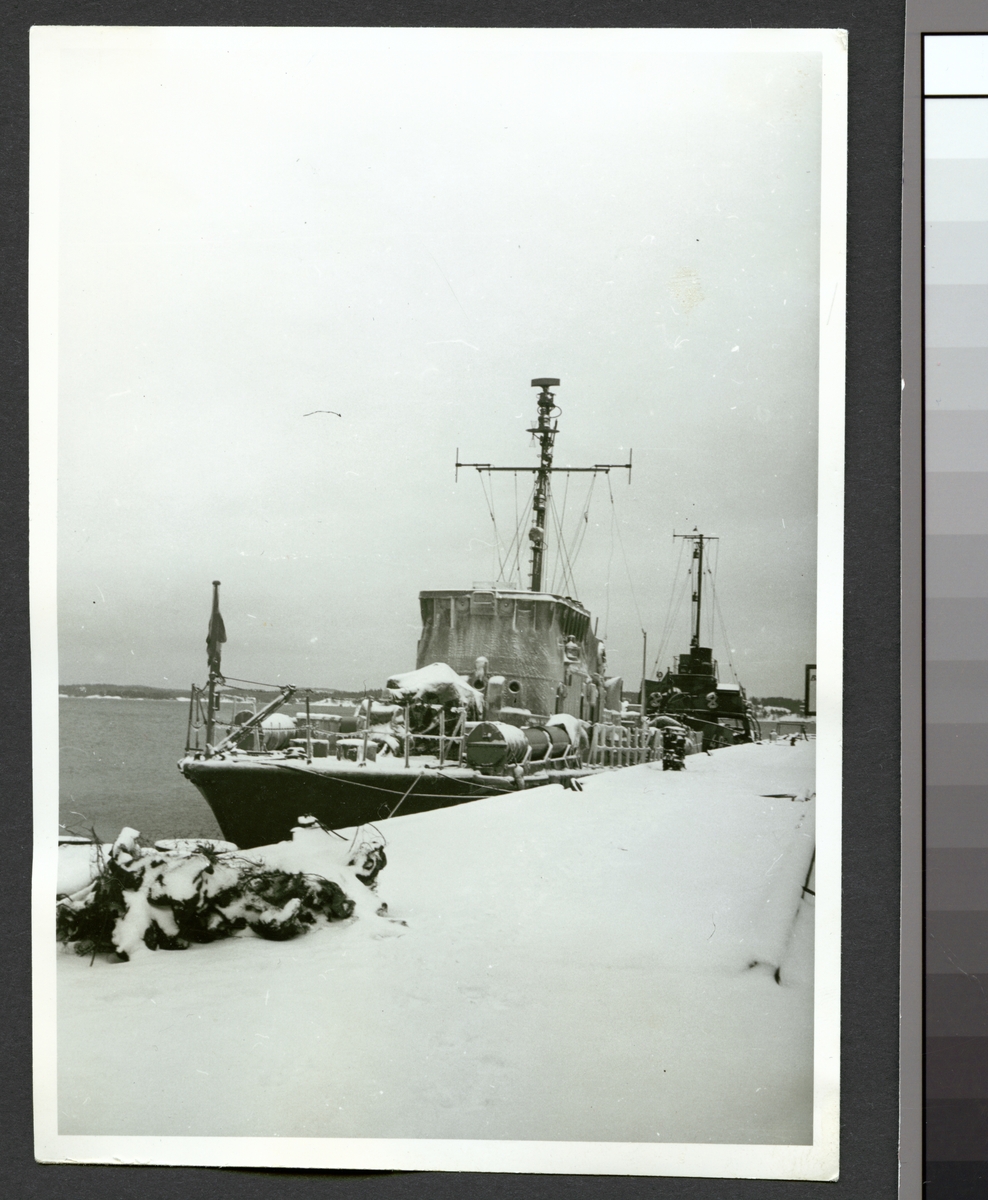 Bilden visar torpedbåten Perseus förtöjt vid kajen under vintertid.