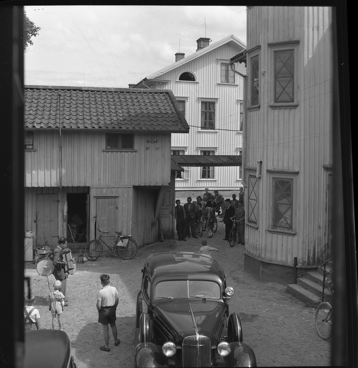 Tells gård med musikant och publik, kv Jägaren. Juli 1950