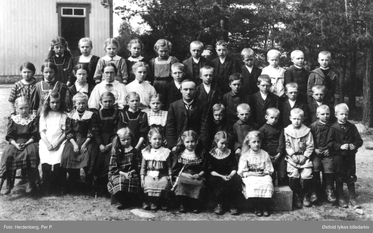 Neaskog skole i Varteig 1910-12, med sin lærer Per Gresset. Navneliste med plassering på bakside av fotokort.